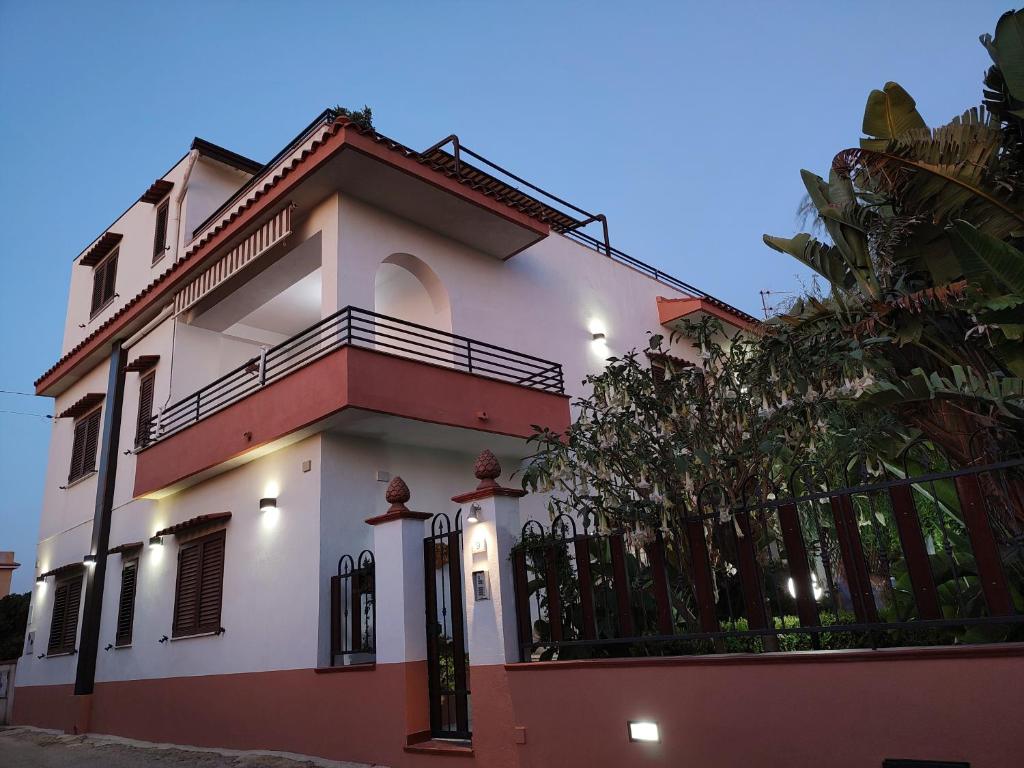una casa blanca y roja con una valla en Sanmarcomare, en Sciacca