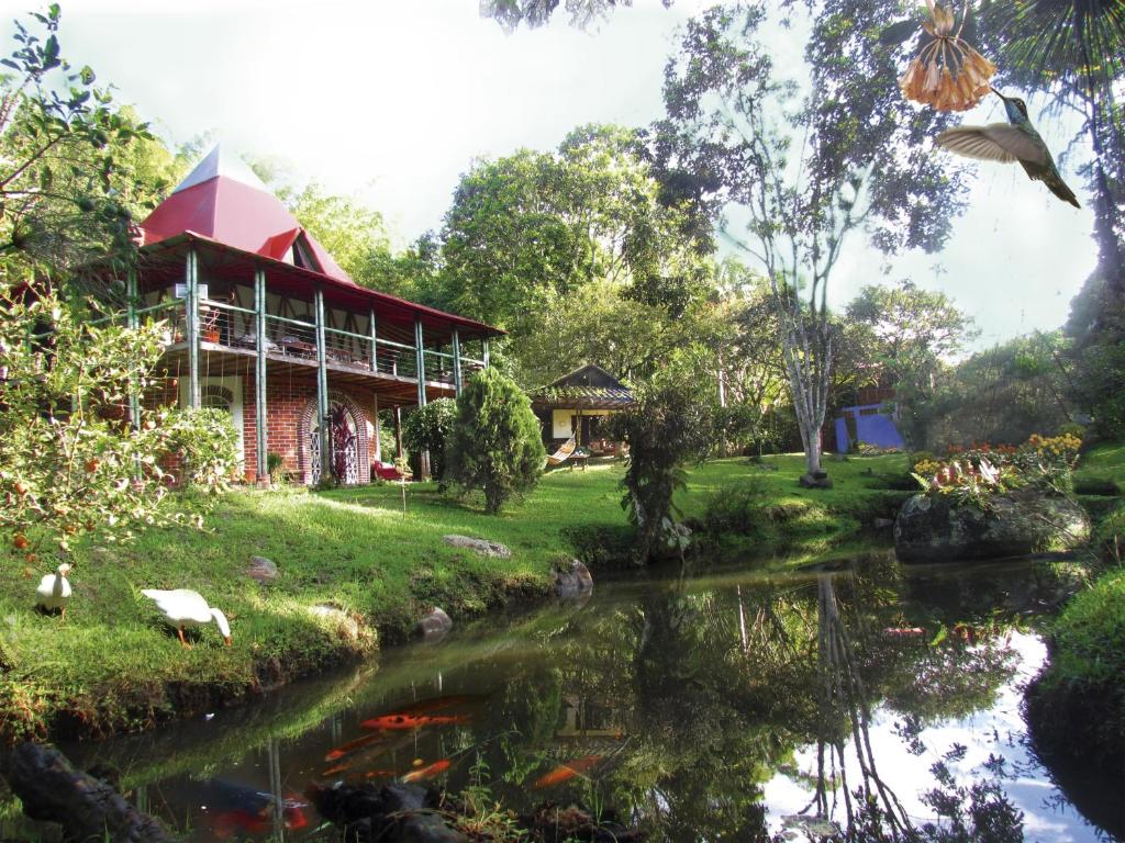 uma casa com um lago em frente em La Posada del Cucú em Salento