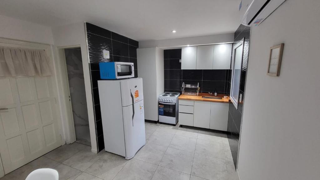 cocina con refrigerador blanca y microondas en Duplex Sol la Perla en Mar del Plata