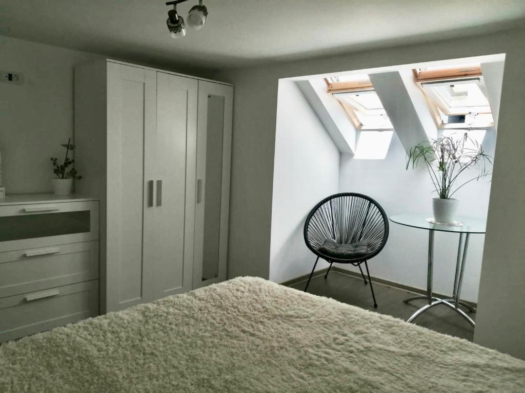 1 dormitorio con 1 cama, 1 silla y 1 mesa en Lovely loft en Cluj-Napoca