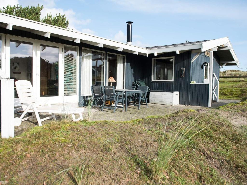 een blauw huisje met een tafel en stoelen ervoor bij Holiday home Fanø LXXIX in Fanø