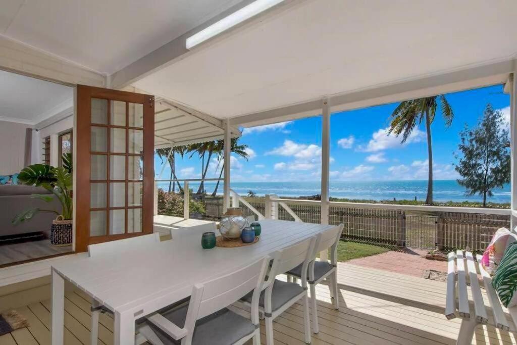 a white dining room with a view of the ocean at Saunders Beach Holiday House 