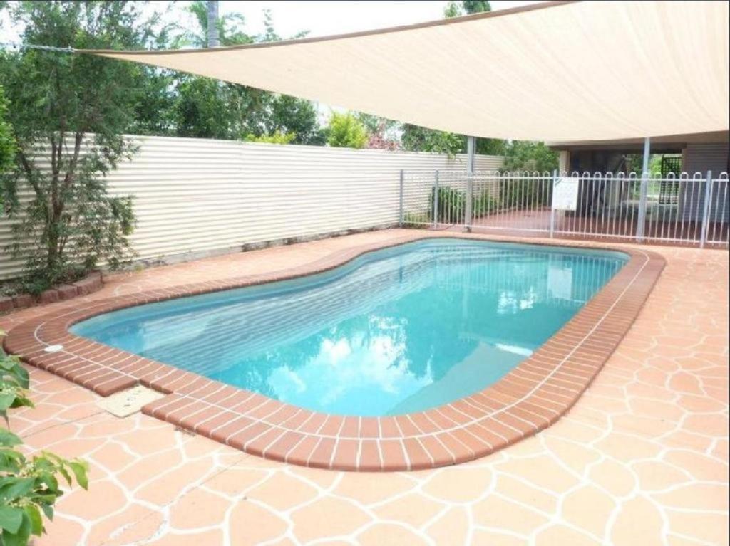 a swimming pool with a brick pathway around it at Aloomba Oasis in Ross River