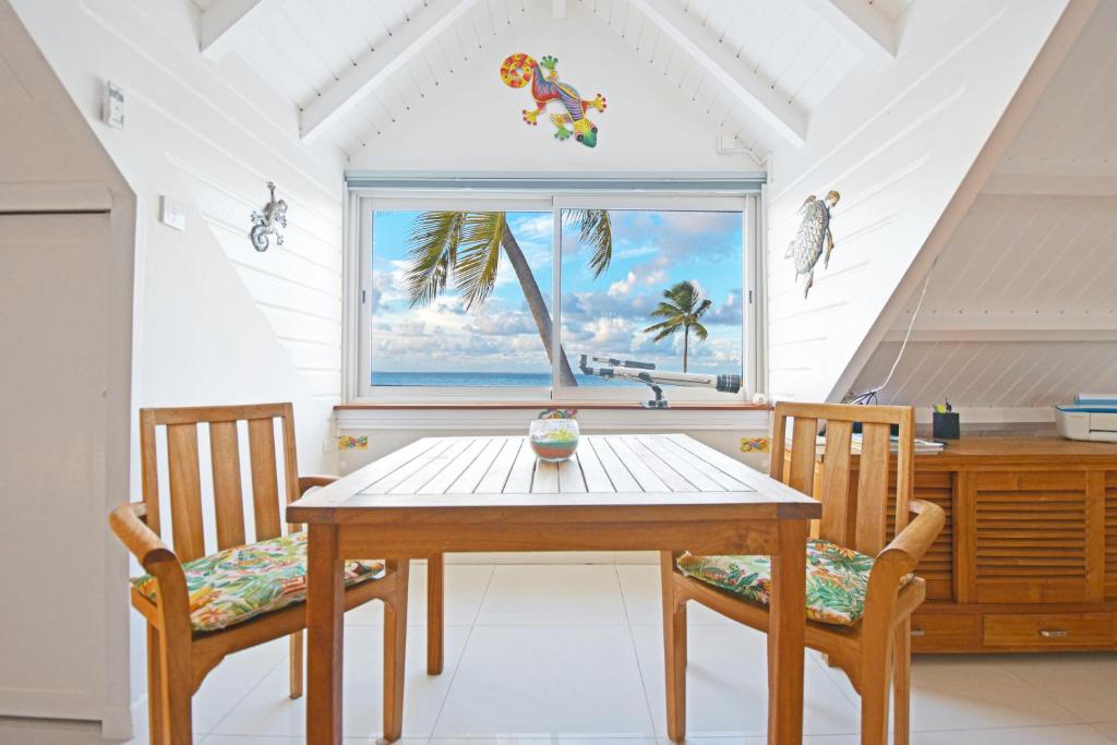 a dining room with a table and two chairs and a window at Deja Blue - Comfortable Beachfront condo in Marigot