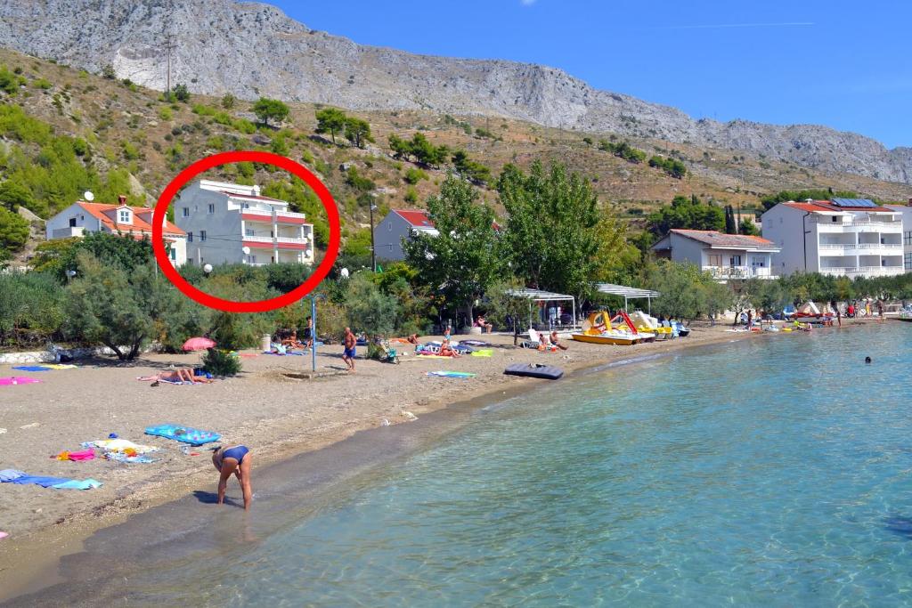 Apartments by the sea Duce, Omis - 8378 في دوغي رات: شخص يقف على شاطئ في الماء