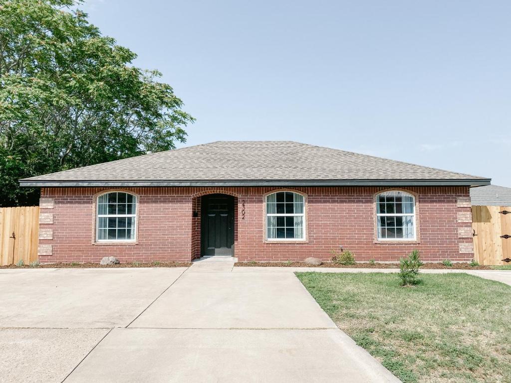 una casa de ladrillo rojo con una puerta negra en The Ruby - Modern Updated 4/2 Home Near ACU, en Abilene