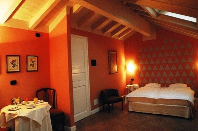 pokój hotelowy z łóżkiem, stołem i krzesłami w obiekcie Hotel Casa Arizzoli w mieście Cannobio