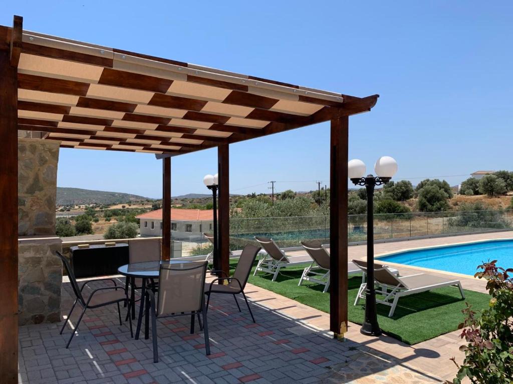 un patio con mesa, sillas y piscina en Magnolia CAPTAINS HOUSE with A POOL, en Limassol