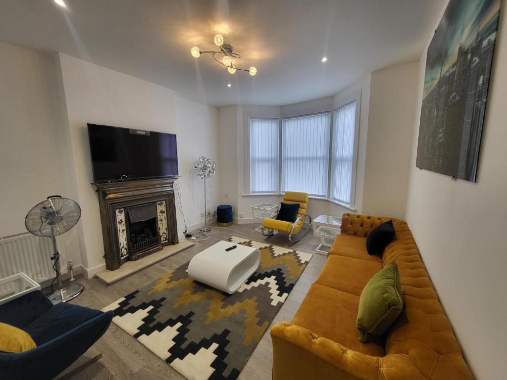 a living room with a couch and a fireplace at Garland Modern 4 Bedroom Central Apartment London in Finchley