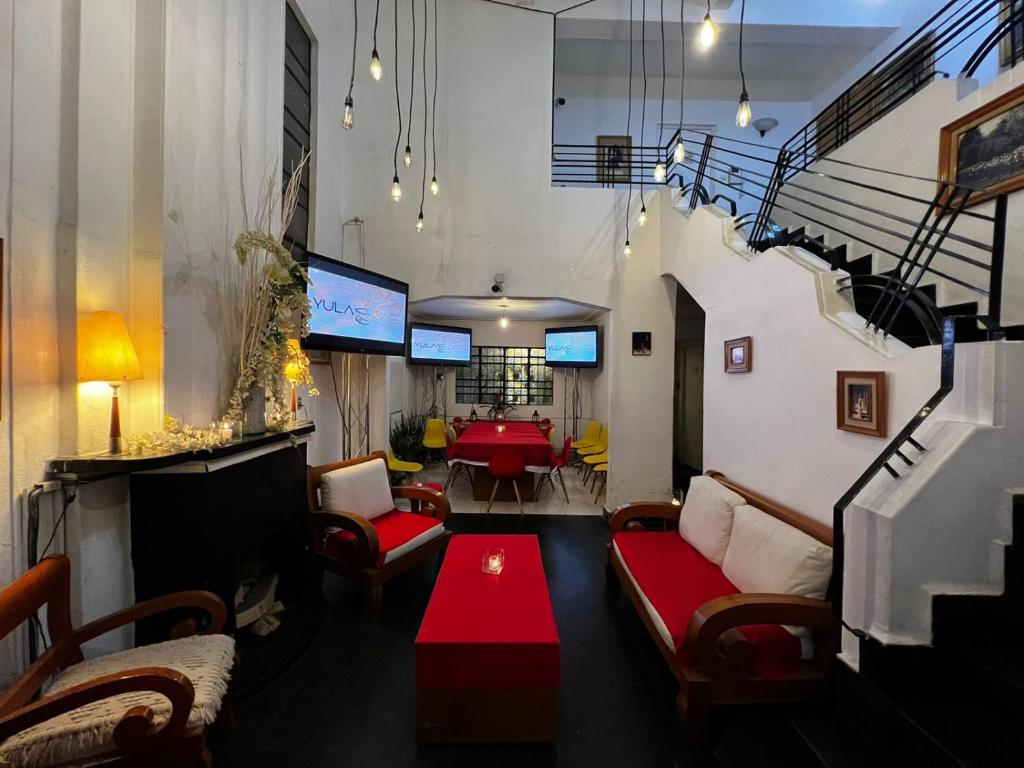 un soggiorno con divani e un tavolo in una camera di Hostal Roma Condesa a Città del Messico