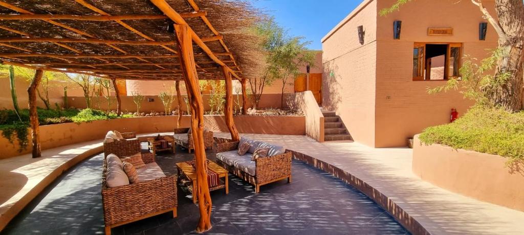 a patio with a table and chairs and a table and chairs at Hotel Pascual Andino in San Pedro de Atacama
