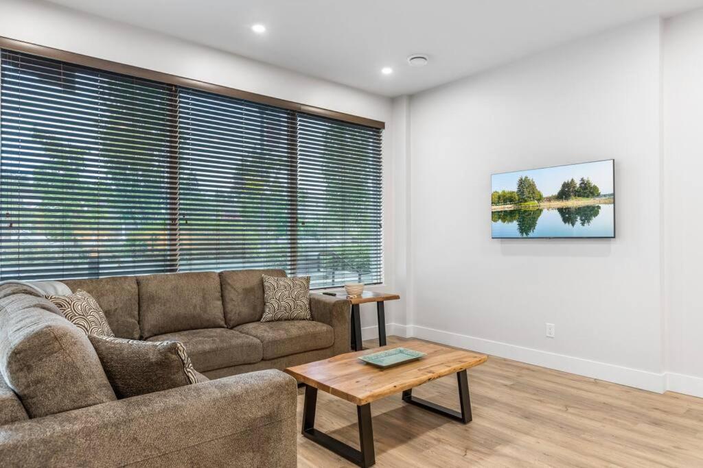 a living room with a couch and a table at Beach Suites in Parksville