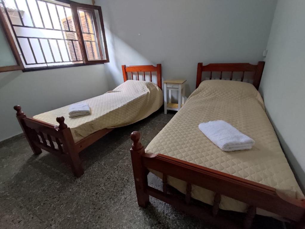 2 Einzelbetten in einem Zimmer mit Fenster in der Unterkunft Casa Barrio Sur COMODA in San Miguel de Tucumán
