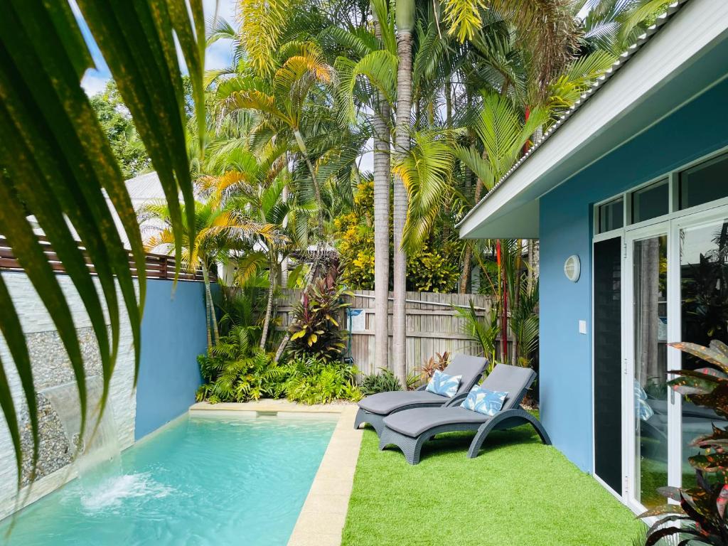 um quintal com uma piscina e uma casa azul em Hanalei Port Douglas - Private Pool em Port Douglas