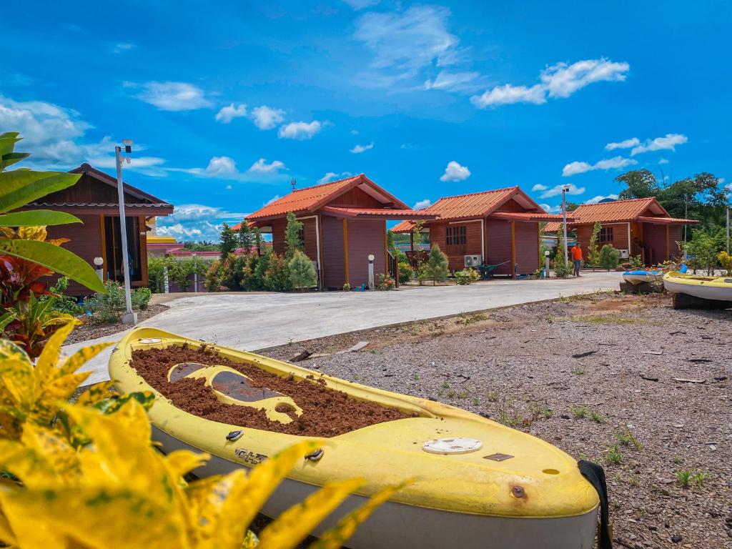 a yellow surfboard sitting in front of some houses at Baan Rung Tawan in Ban Bang Nao