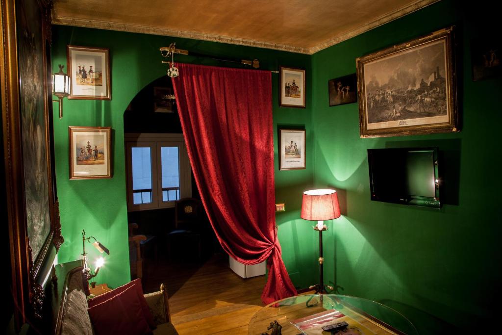 a living room with a red curtain and green walls at Repubblica Di Oz Rooms in Varese