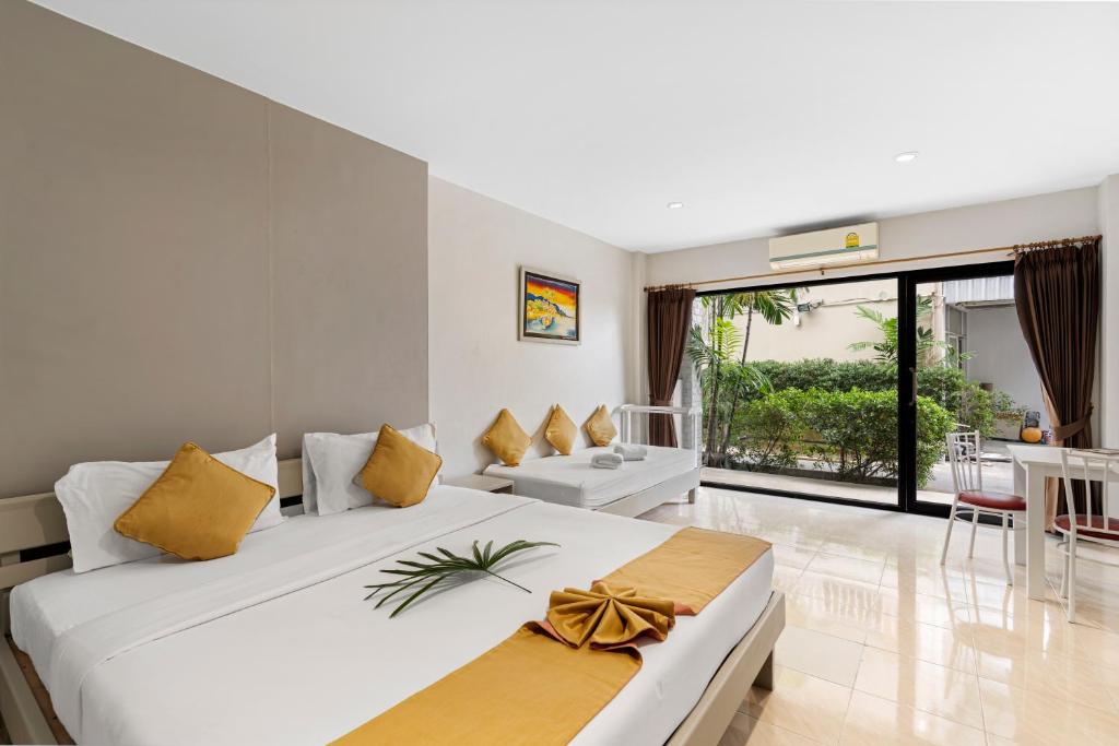 a bedroom with a large white bed with yellow pillows at Chaweng Terrace in Chaweng