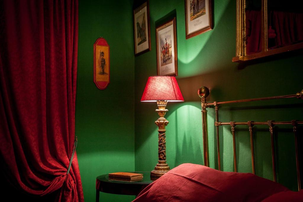 a bedroom with green walls and a lamp next to a bed at Repubblica Di Oz in Varese