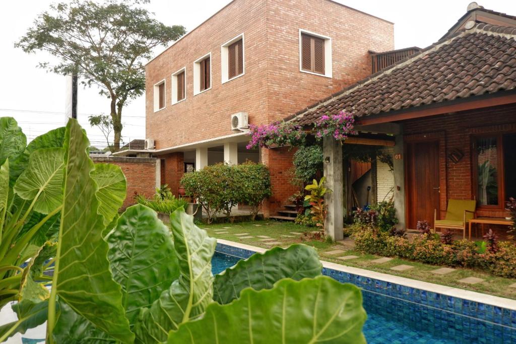 una casa con piscina frente a una casa en Rumah Bata Guest House, en Licin