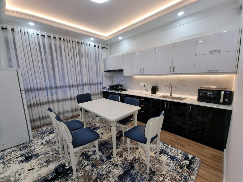 eine Küche mit einem weißen Tisch und Stühlen in einem Zimmer in der Unterkunft Квартира в аренду Tashkent in Taschkent