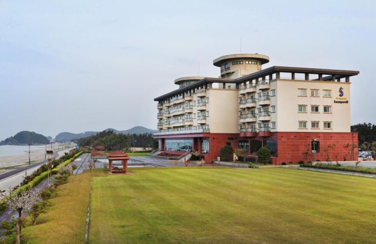 un grand bâtiment avec une pelouse devant lui dans l'établissement Seaspovill Resort, à Samcheok