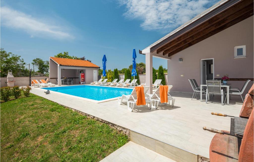 a patio with chairs and a swimming pool at Awesome Home In Valtura With 6 Bedrooms, Wifi And Outdoor Swimming Pool in Valtura