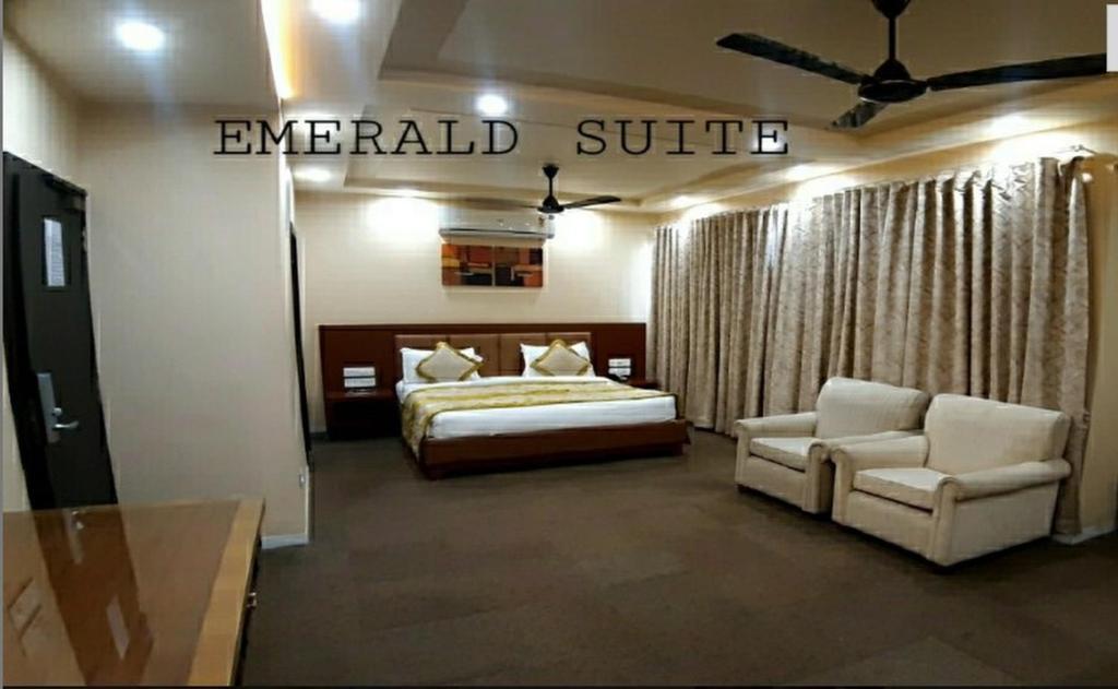 a hotel room with a bed and a couch at The Emerald Club ,Rajkot in Rajkot