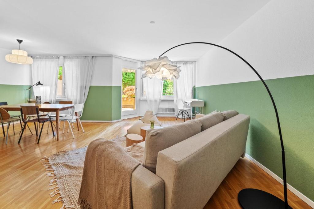 uma sala de estar com um sofá e uma sala de jantar em Beautiful Boutique Apartment DRAHTZUG16 em Zürich