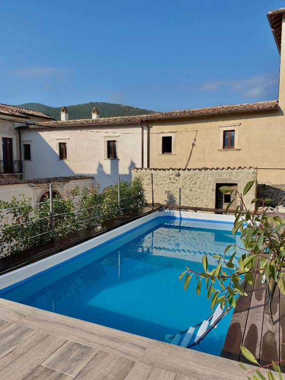 a large blue swimming pool in front of a building at Dimora dell'Arte-CantinArte in Navelli