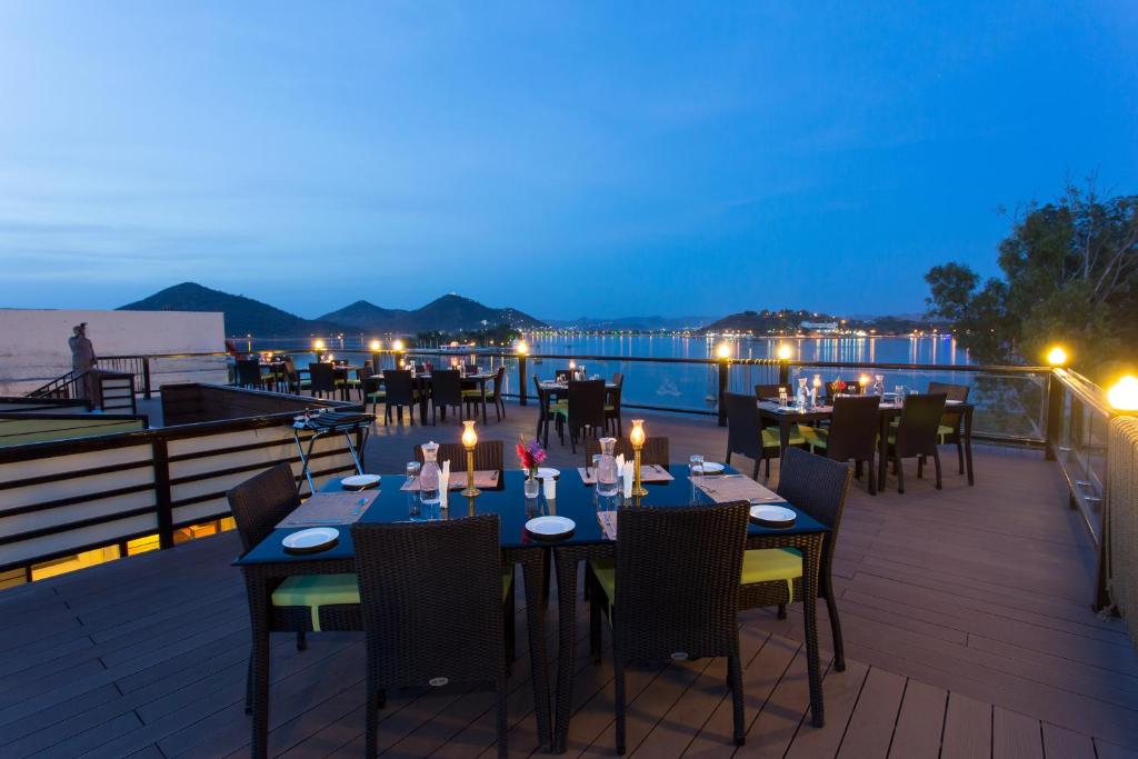 a restaurant with tables and chairs on a deck at night at Panna Vilas - A Lake Facing Boutique Hotel in Udaipur