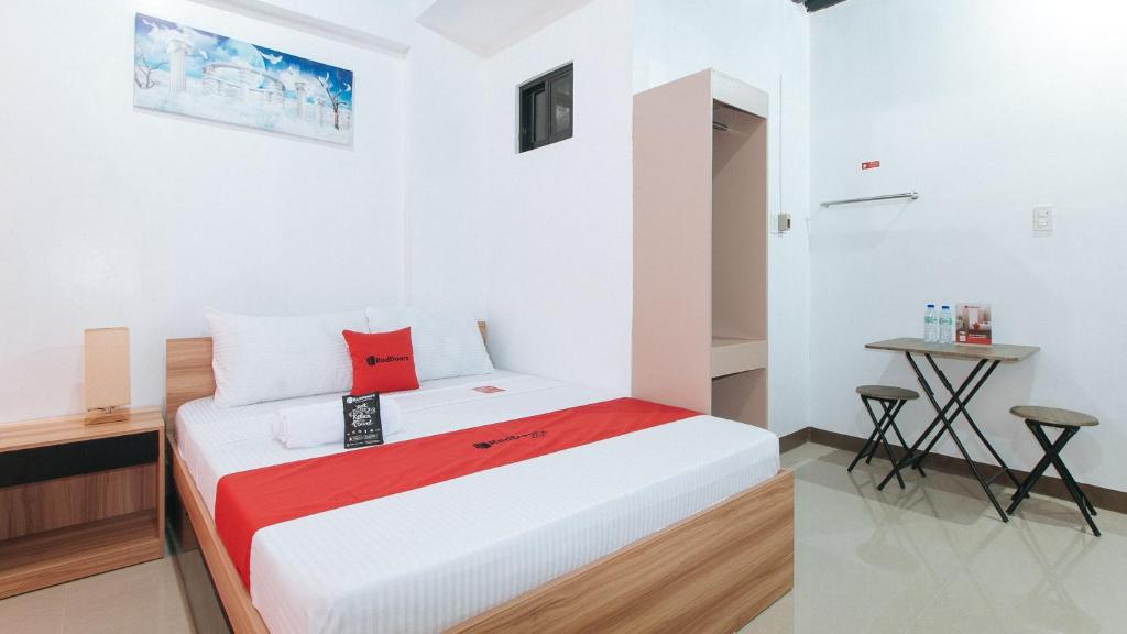 a bedroom with a bed and a small table at RedDoorz Near Iloilo International Airport in Iloilo City