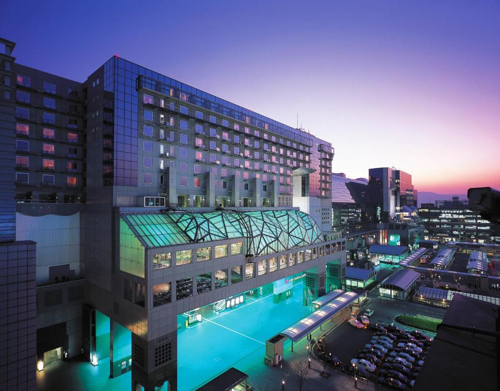 a large building with a pool in front of it at Hotel Granvia Kyoto in Kyoto