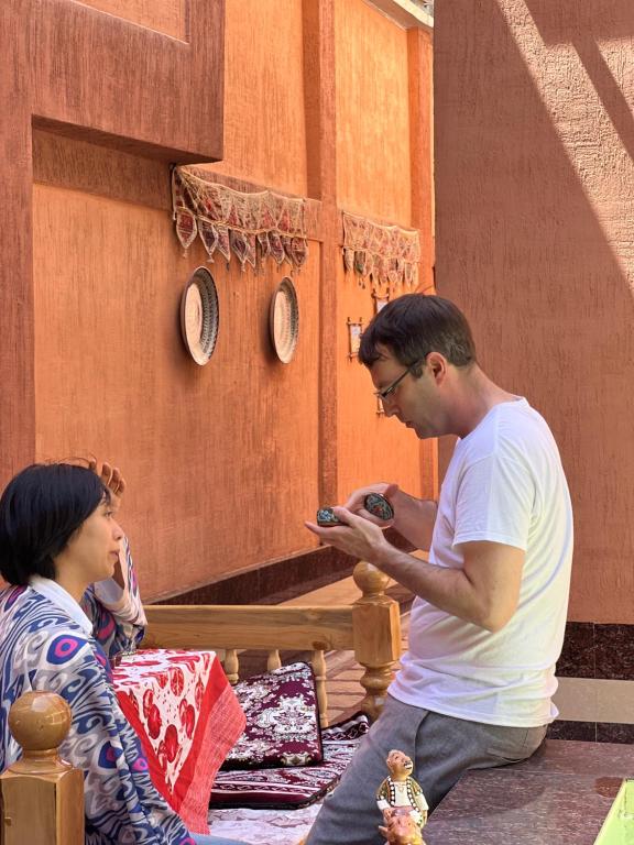 un hombre y una mujer mirando un celular en SHAHNOZA GRAND en Samarcanda