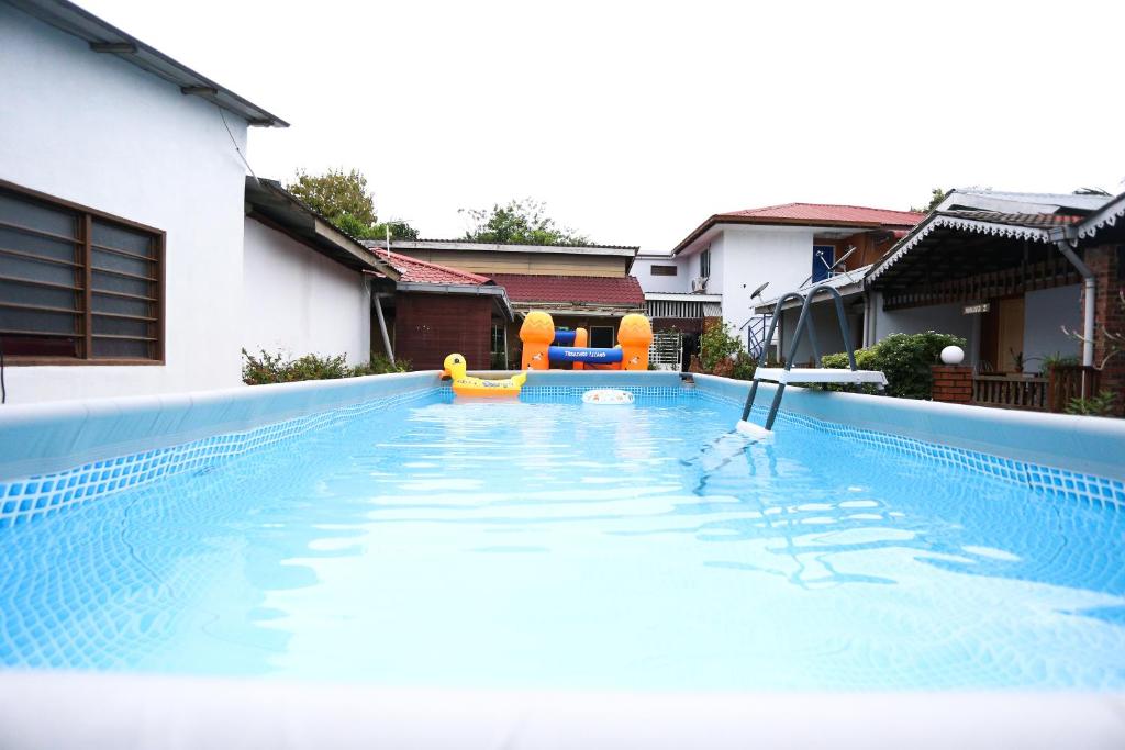 einen Pool mit zwei Stühlen in einem Haus in der Unterkunft Pondok Muara Chalet in Pantai Cenang