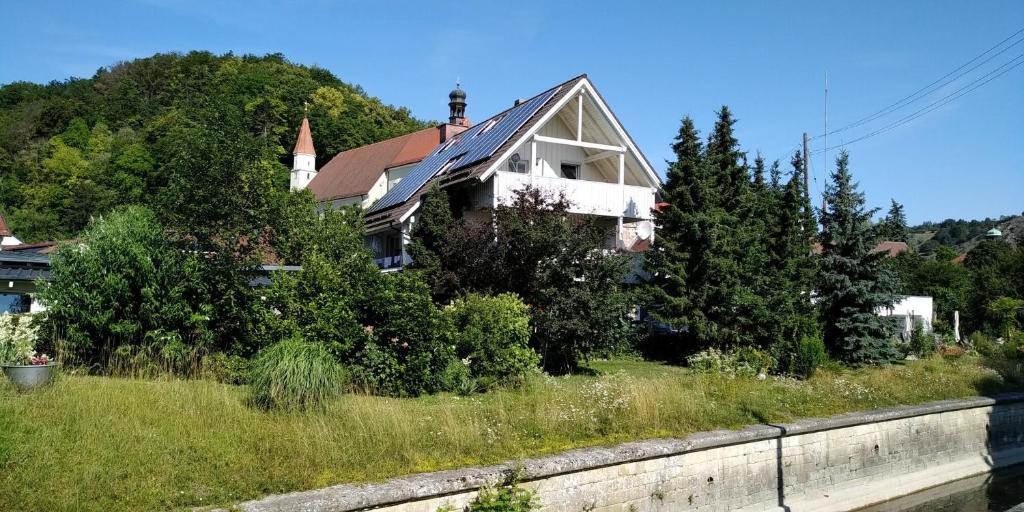 una casa en una colina junto a un río en Ferienwohnungen am historischen Ludwigskanal, en Kelheim