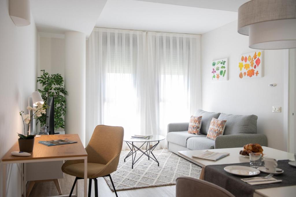 un soggiorno con divano e tavolo di Apartamentos Aura Park Fira BCN a Hospitalet de Llobregat