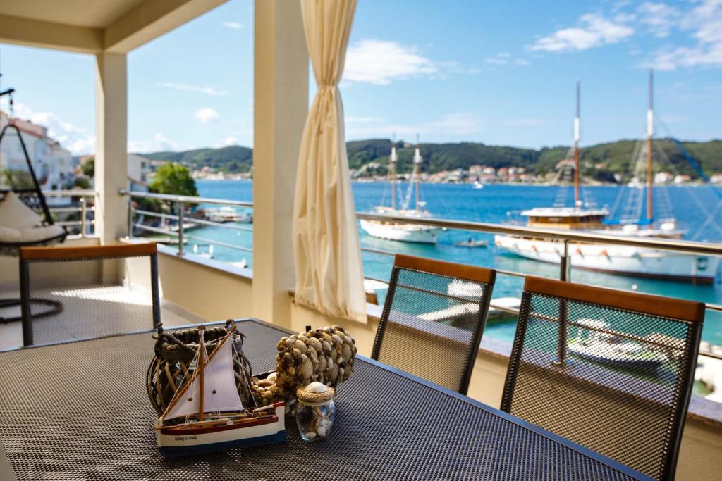 a table on a balcony with a view of the water at Villa Guliva in Rab