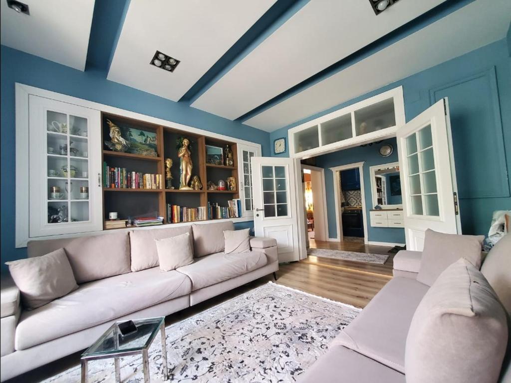 a living room with a white couch and blue walls at Apartamenti8 Korca in Korçë