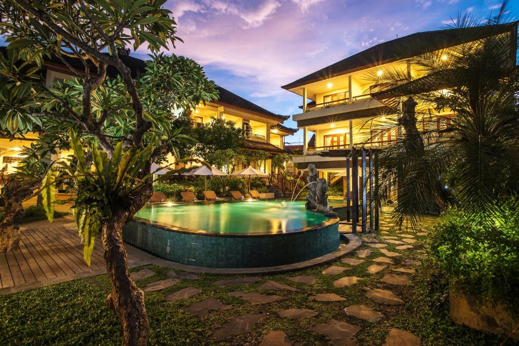 a house with a swimming pool in front of a building at Sri Phala Resort & Villa in Sanur