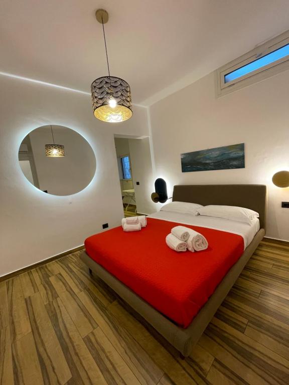- une chambre avec un lit et une couverture rouge dans l'établissement BB4U Apartments al Massimo, à Palerme