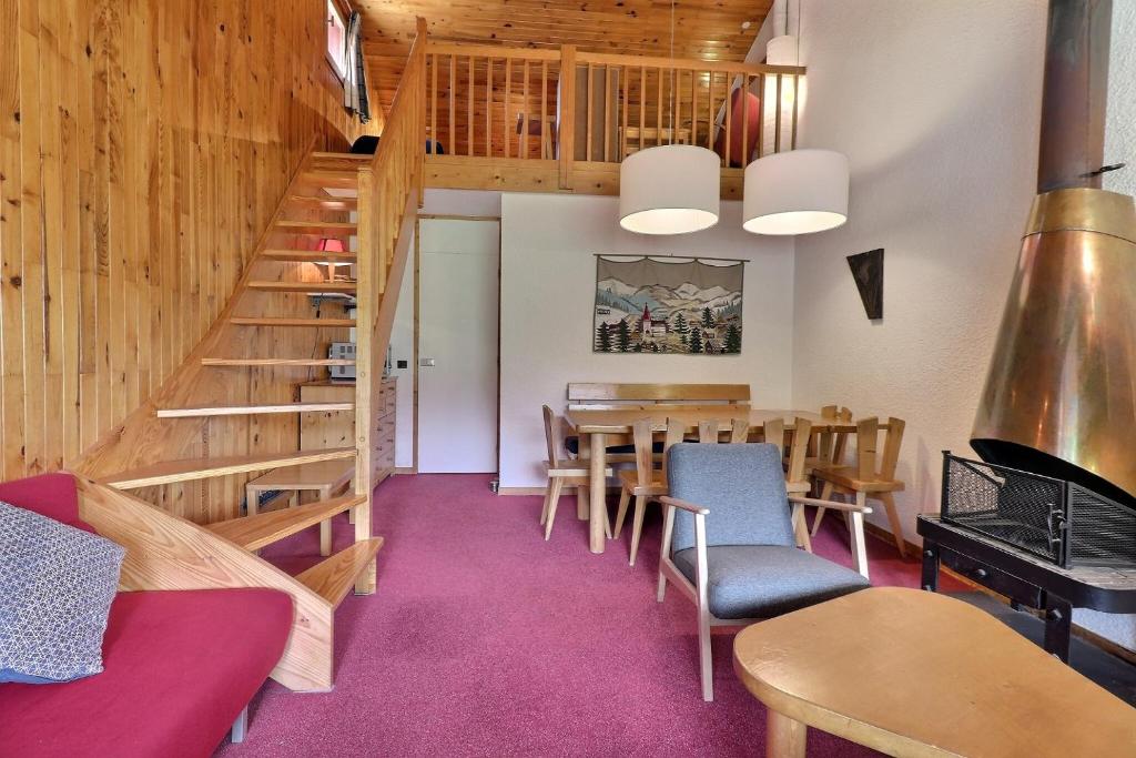um quarto com uma mesa e cadeiras e uma escada em Residence Saulire em Méribel