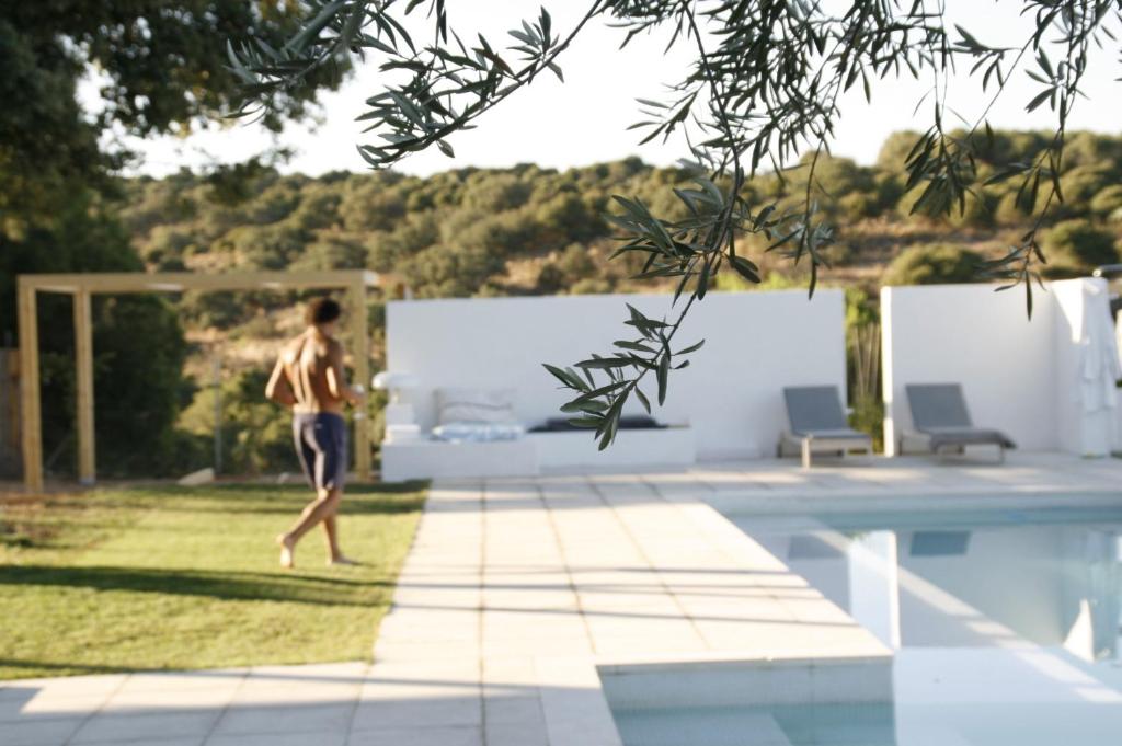 a man walking by a swimming pool at Espacio Natural in Valdemorillo