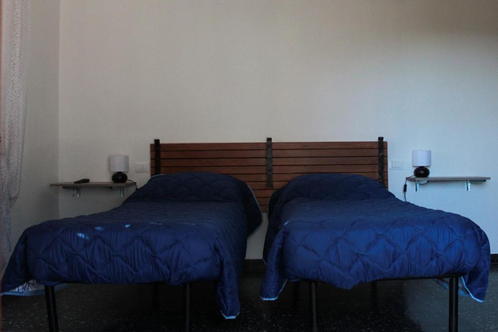 a room with two blue beds in a room at La casa della zia in Albiano