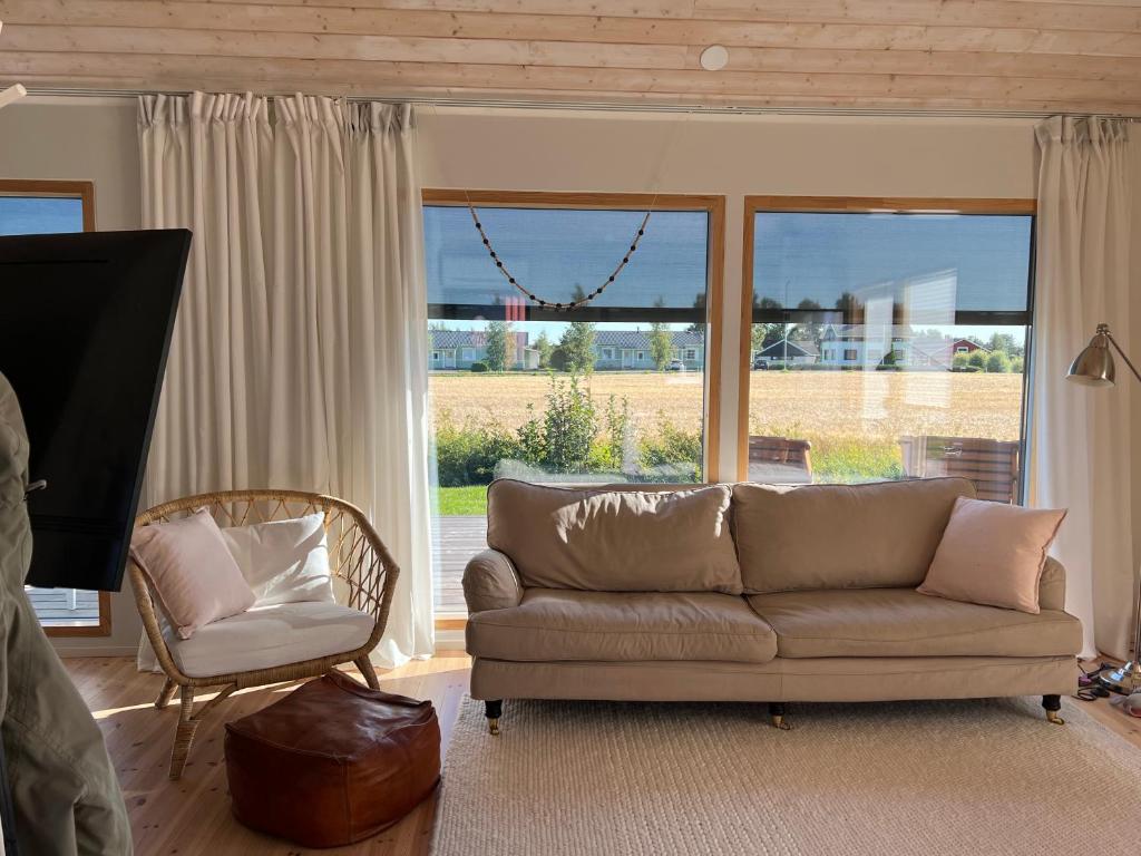 a living room with a couch and a chair and a window at Soda Home - The Tiny House - 24h check in in Närpiö