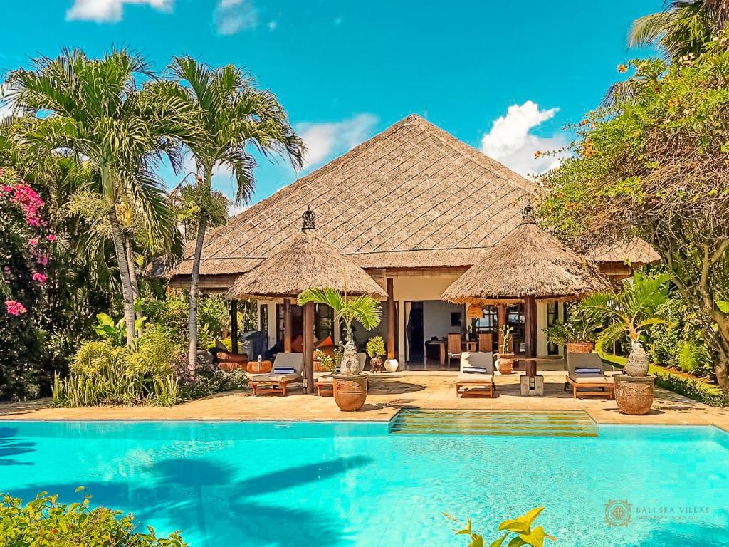 a house with a swimming pool and a resort at Villa Bidadari - Bali Sea Villas Beachfront and private pool in Pengastulan