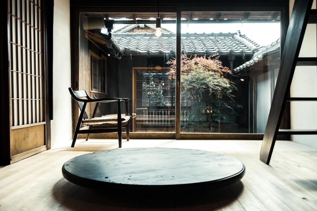 Tamba-sasayamaにあるOito 美しい街並みに佇む喫茶と宿のテーブルと椅子、窓が備わる客室です。