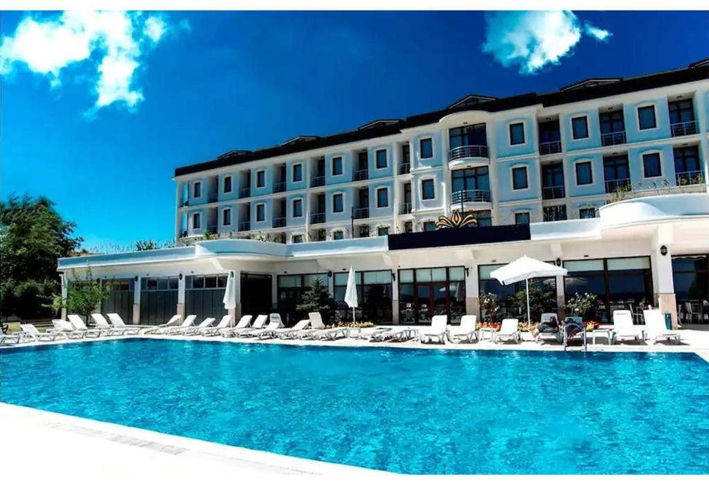 a hotel with a swimming pool and chairs and a building at Westport Istanbul Resort & Spa Hotel in Silivri