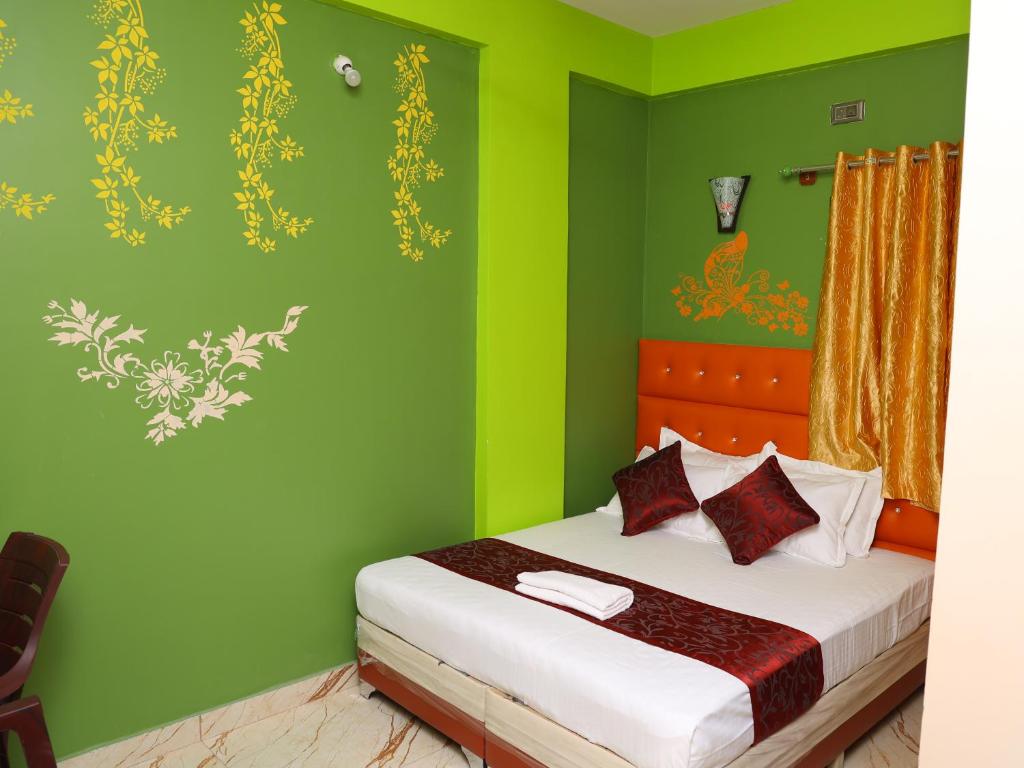 YelahankaにあるHotel Sas Royal Galaxy By WB Innの緑の壁のベッドルーム1室