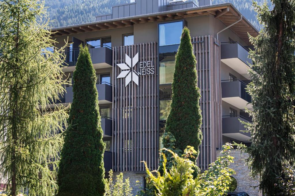 a building with trees in front of it at Hotel Edelweiss in Saalbach Hinterglemm