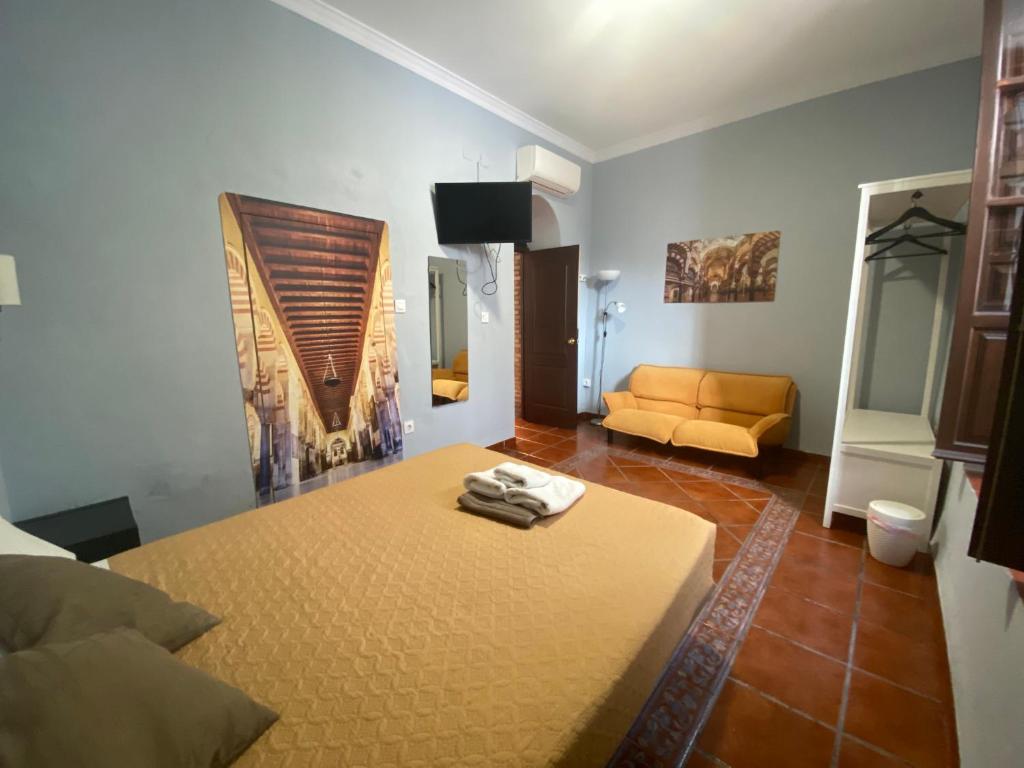 コルドバにあるPatio de la Plateriaのベッドとソファが備わる部屋
